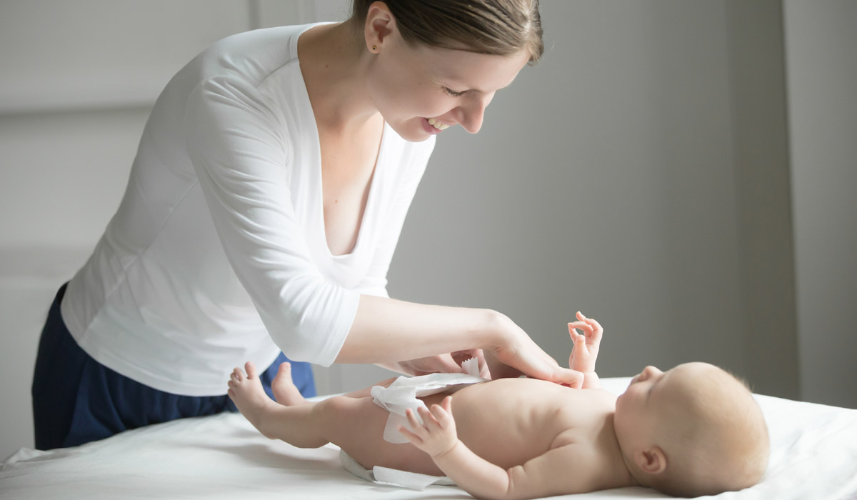 Mamma che cambia il pannolino al suo bambino - il momento del cambio