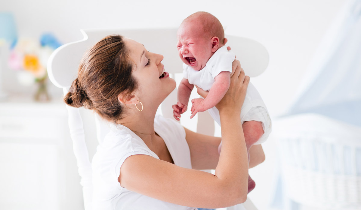 Mamma con neonato che piange - le possibili motivazioni del pianto del bambino