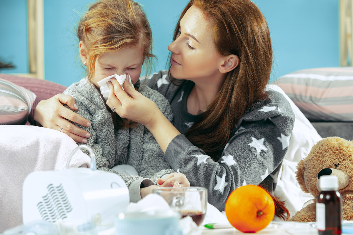 Mamma che asciuga il nasino a sua figlia - raffreddore bambini