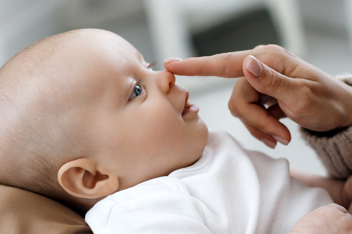 Le cure primarie del neonato - mamma che tocca il nasino del suo bambino - igiene e cura del nasino del neonato