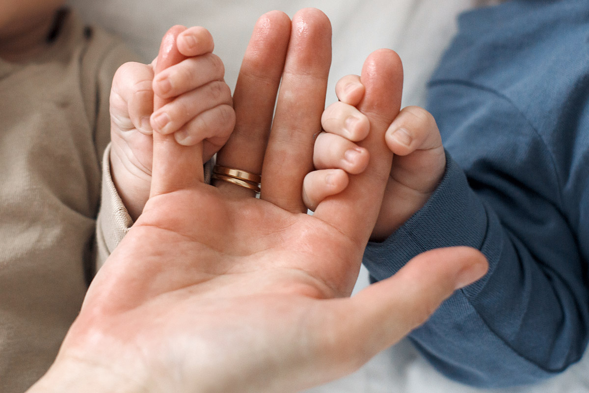 Le cure primarie del neonato - bimbi che tengono la mano del genitore - come prendersi cura delle unghie del bambino