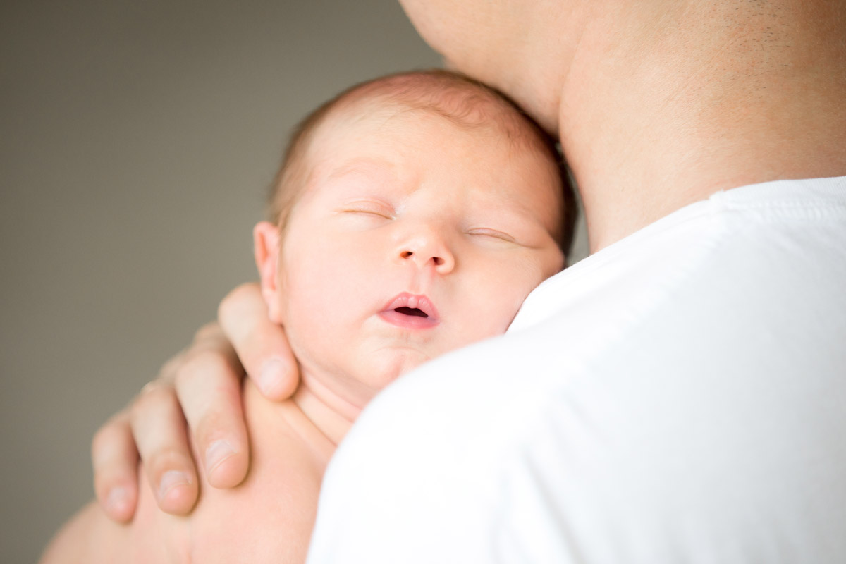 Neonato che dorme in braccio al suo papa - Bonding neonatale