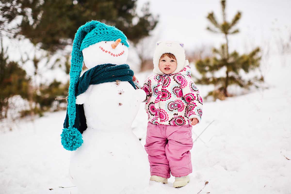 Consigli utili bambini e freddo: bambina ben coperta sulla neve