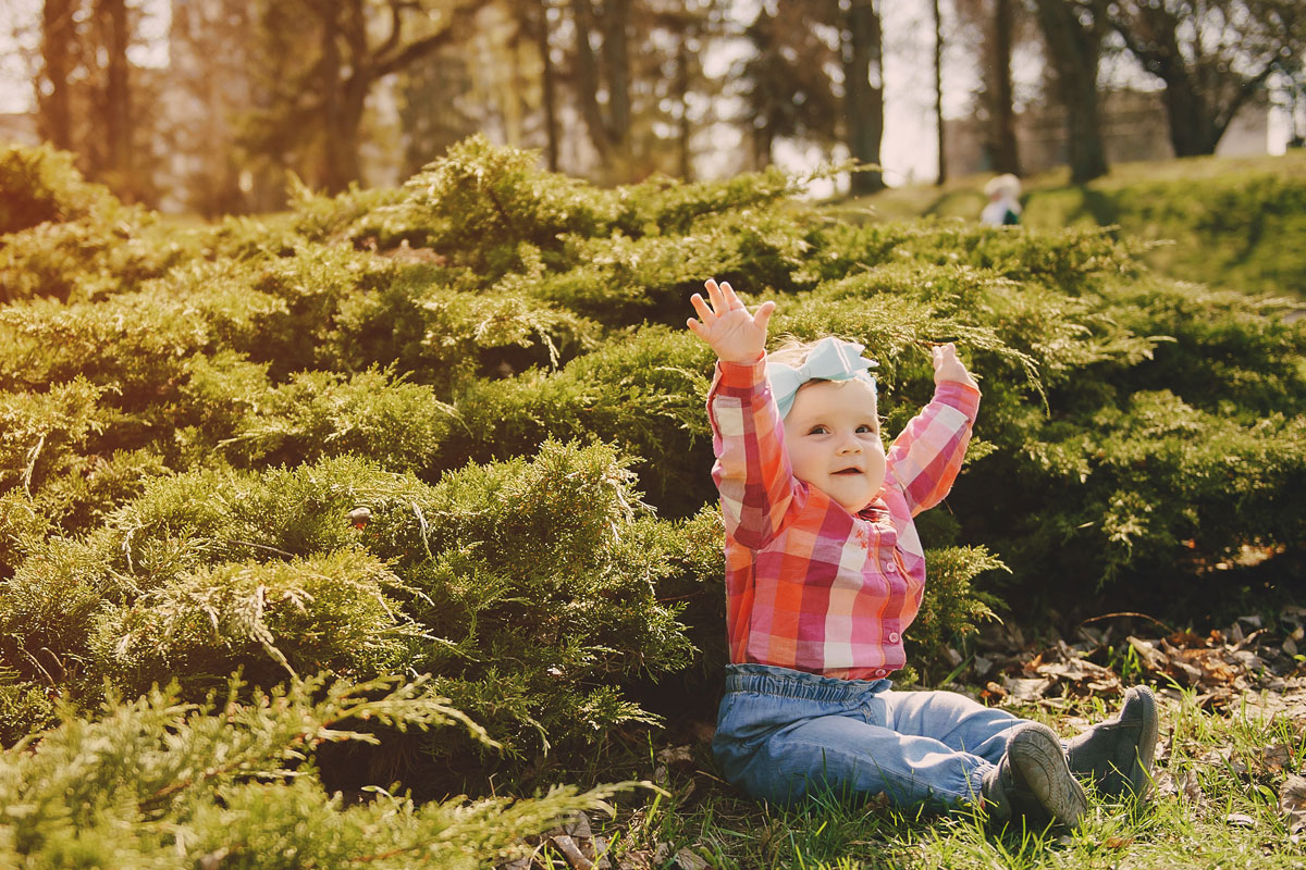 Bambini e la montagna - Bimba felice seduta sul prato