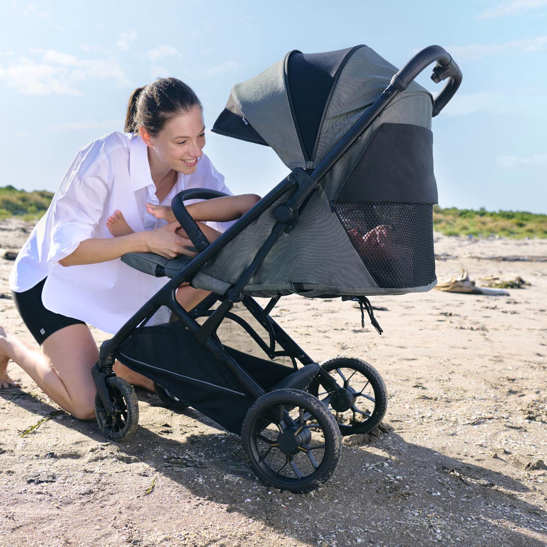 Mamma e bambino sul passeggino al mare