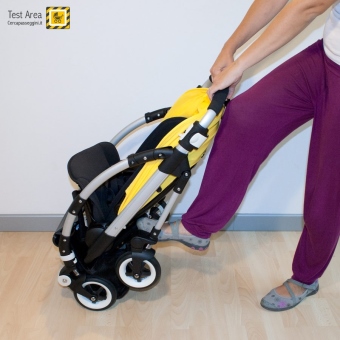 Bugaboo Bee 3 e Carrozzina - Fase di chiusura - fronte strada - spingere con il piede sull'asse delle ruote posteriori e contemporanemente tirare verso di s il maniglione