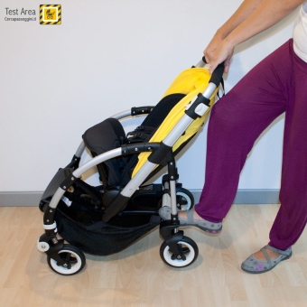 Bugaboo Bee 3 e Carrozzina -  Fase di chiusura - fronte strada - spingere con il piede sull'asse delle ruote posteriori e contemporanemente tirare verso di s il maniglione