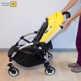 Bugaboo Bee 3 e Carrozzina - Fase di chiusura - fronte mamma - Premere i due pulsanti e contemporaneamente tirare verso l'alto le leve, sui lati del maniglione
