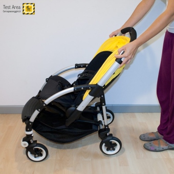Bugaboo Bee 3 e Carrozzina - Fase di chiusura - fronte strada - Premere i due pulsanti e contemporaneamente tirare verso l'alto le leve, sui lati del maniglione. 