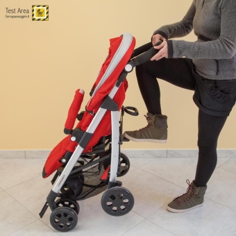 Foppapedretti TUO - Fase di apertura - mossa 3 - tenendo il passeggino dal maniglione, spingere con il piede la pedana posta al centro del telaio