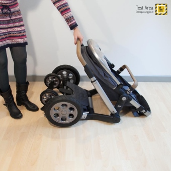 Joolz Day Quadro -  Fase di apertura con passeggino posato a terra - mossa 1b - Sollevare il maniglione verso l'alto.