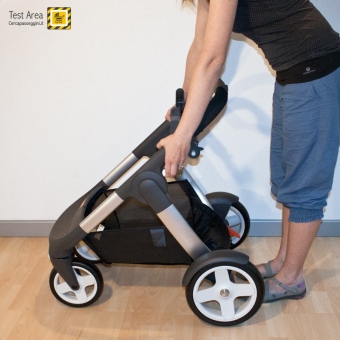 Stokke Crusi Duo - Fase di chiusura - mossa 2 - Premere pulsanti per sbloccare telaio
